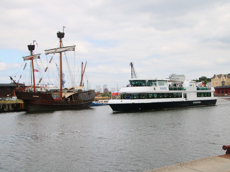 Historisch schip en moderne boot in de haven van Lübeck