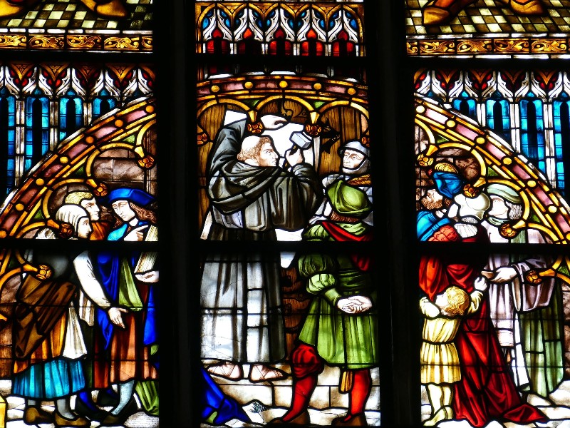 Glas-in-lood afbeelding van Luther die zijn stellingen ophangt