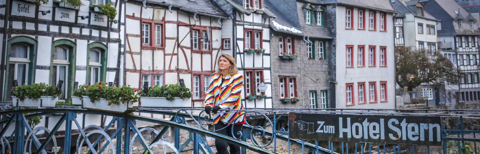 Sabine kijkt uit over de Rur in het historisch centrum van Monschau in de Eifel in Duitsland