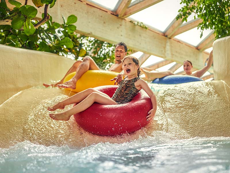 Spelen op de glijbaan van het waterpark bij Center Parcs Nordseekuste in Duitsland