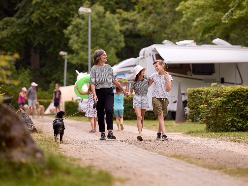 Campinggasten wandelen over de gezinsvriendelijke RCN camping Laacher See in de Eifel in Duitsland