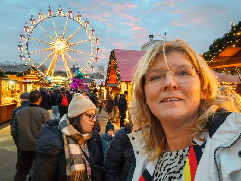 Sabine op de kerstmarkt met het reuzenrad op de achtergrond