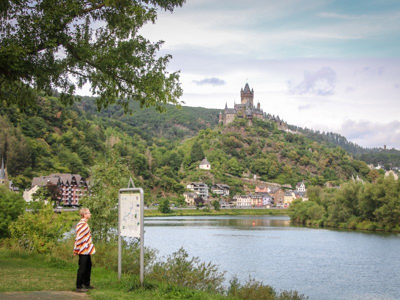 Patrick kijkt uit over de Moezel met op de achtergrond de rijksburcht van Cochem