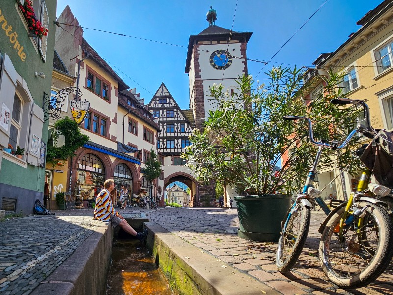 Patrick geniet van de watergoten en stadspoort van Freiburg