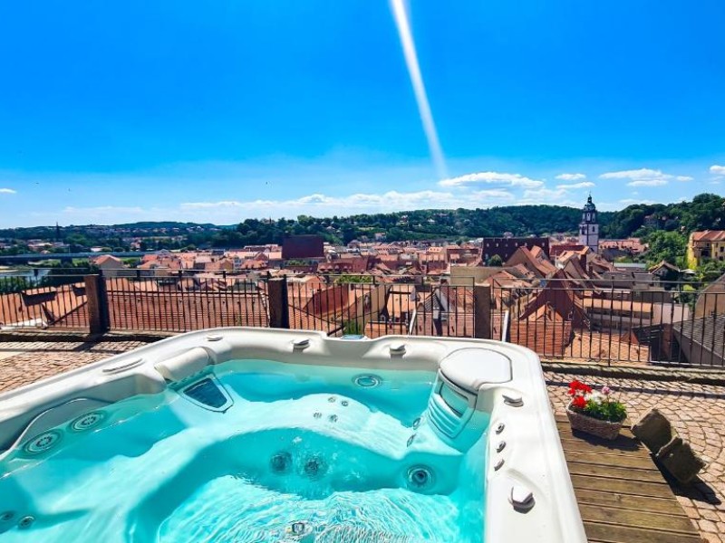 Een jacuzzi op het terras met uizicht over de stad, alles kan bij Hotel Burgkeller