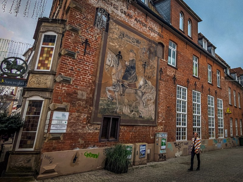 Patrick wandelt voor een muurschildering van Graaf Anton Günther in Oldenburg