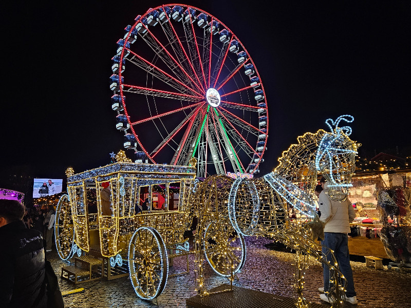 Het reuzenrad en het paard en wagen lichtobject  op de kerstmarkt in Potsdam