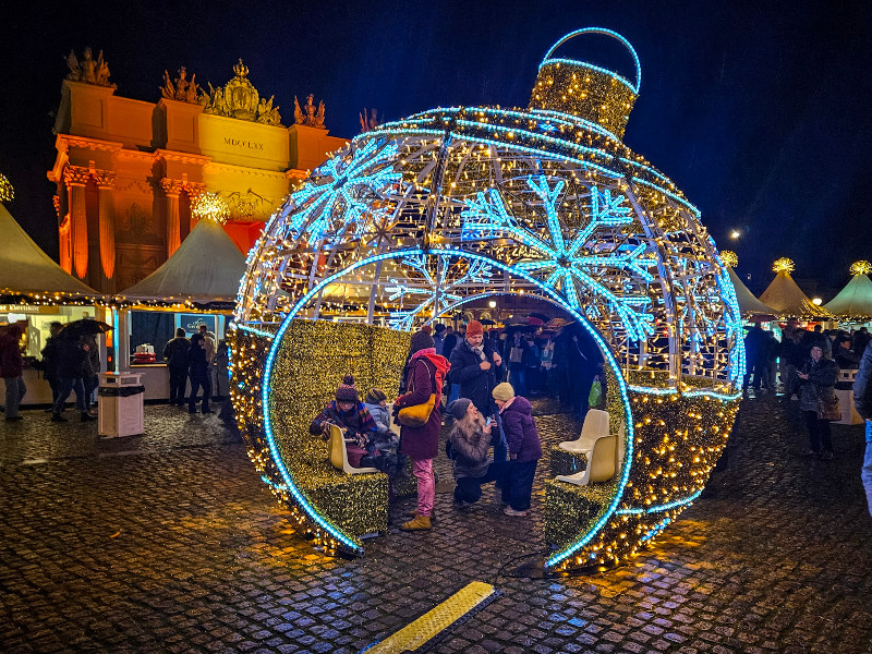 De kerstbal op de Luisenplatz met de Brandenburger Tor op de achtergrond