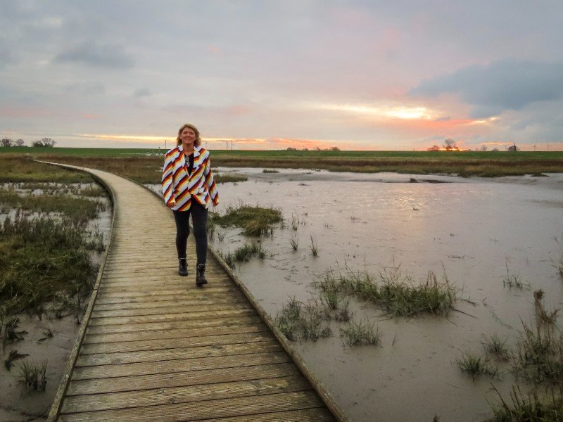 Sabine loopt op een steigerpad door de mooie natuur van Butjadingen